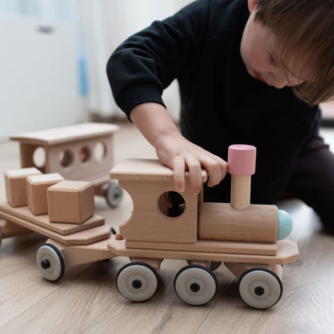 Junge spielt mit Lokomotive aus Holz, Lotte unser Holzzug, der ohne Schienen fährt