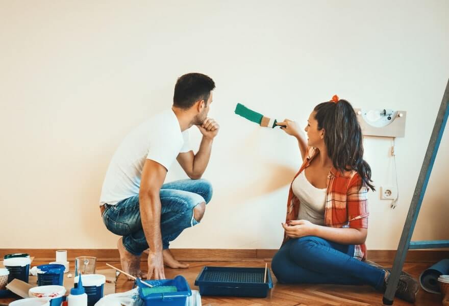 man-and-woman-painting-wall-trending-wall-colours-for-2023