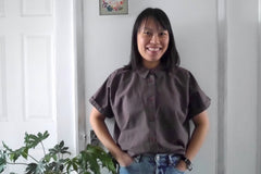 Lady wears a short sleeved button-front shirt in Organic Cotton & Hemp fabric