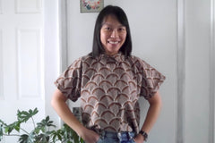 Lady wears a short sleeved button-front shirt in Organic Cotton fabric