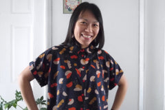 Lady wears a short sleeved button-front shirt in EcoVero Viscose fabric