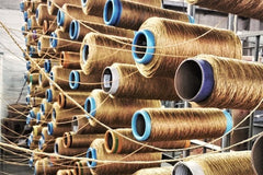 Rows of brown thread reels on industrial machine