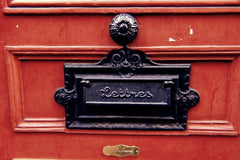 Metal letter box on wooden red door