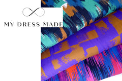 Three bolts of patterned fabrics in a pile fanned out, beneath the text logo "My Dress Made"