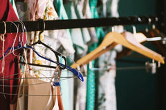 Close up of clothes on mismatched hangers on metal rail