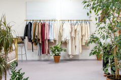 A variety of clothes hung on hangers on a rail.