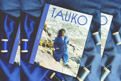 Tauko magazine displayed on top of fabric surrounded by thread spools