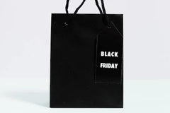 Black paper bag with a tag with 'Black Friday' printed on it