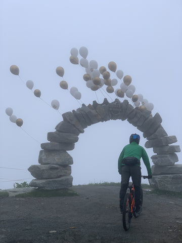 Bikepark Bikerepublic Sölden Mountainbiker fährt durch Steinbogen mit Luftballons