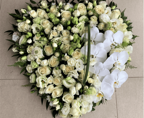 Solid funeral heart wreath with white flowers.