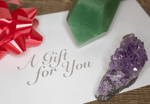 Gift certicate with bow, amethyst cluster, and green aventurine point