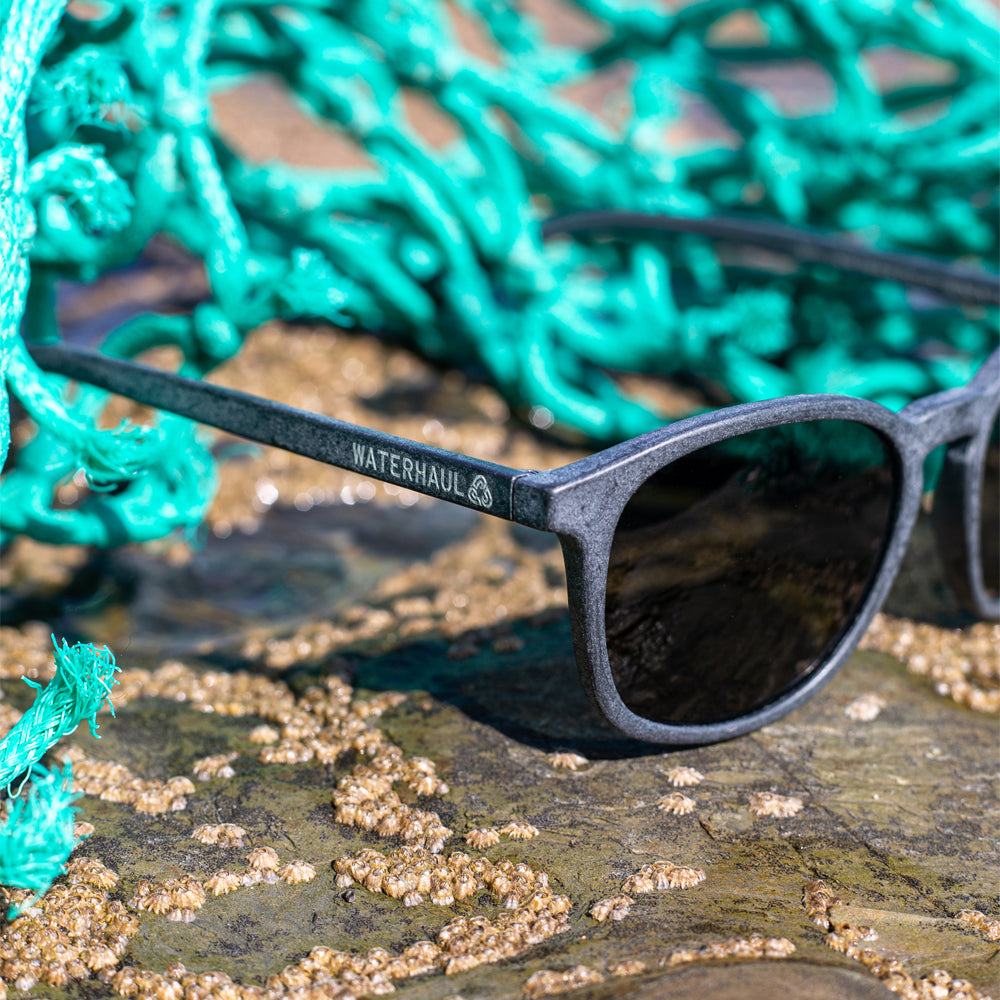 waterhaul kynance recycled sunglasses sitting on mussels with fishing net in background