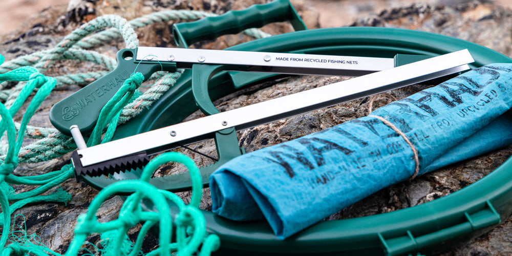 litter picking equipment on a rock, with fishing net in the foreground