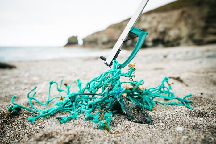 Litter picker being used on beach clean collecting ghost gear