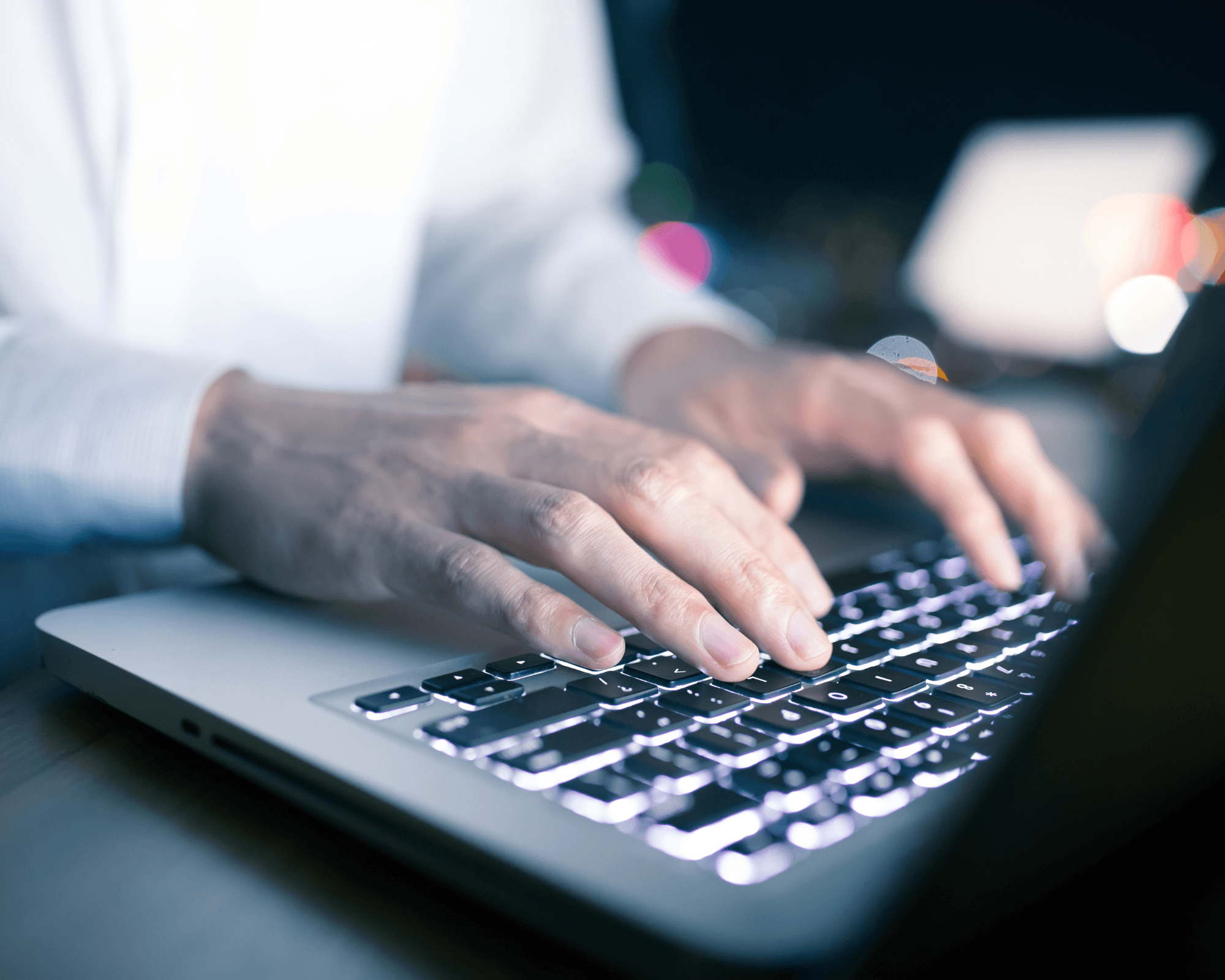 Hands typing on a laptop keyboard