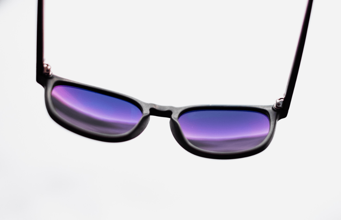 Sunglasses in white studio with purple reflection on lenses