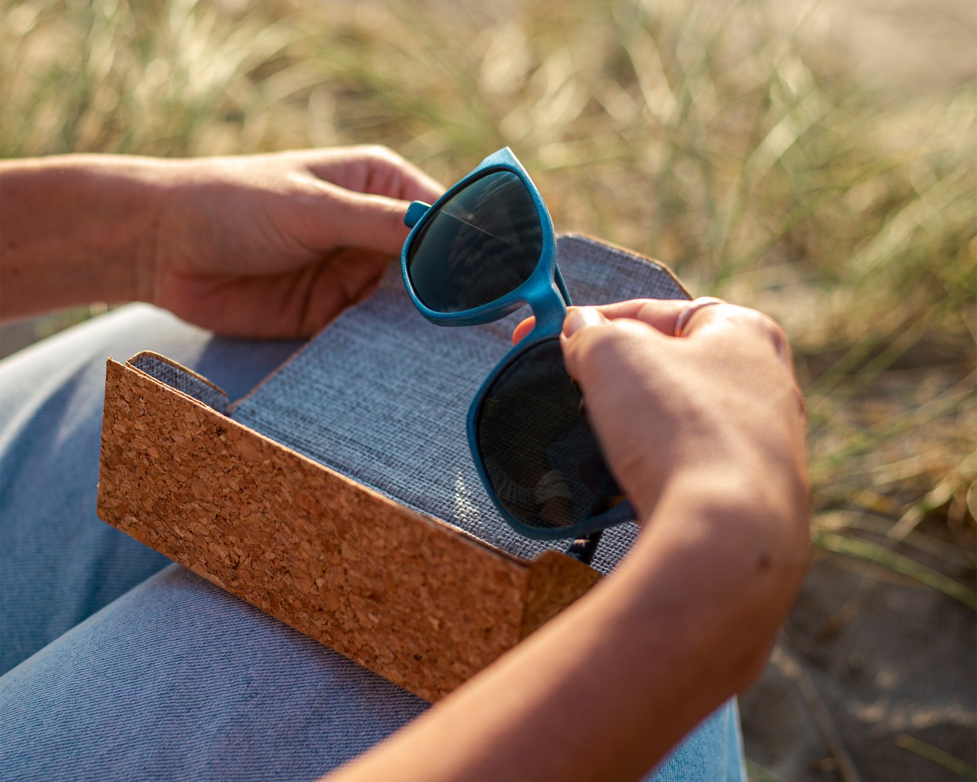 Navy waterhaul fitzroy sunglasses being taken out of cork folding sunglasses case