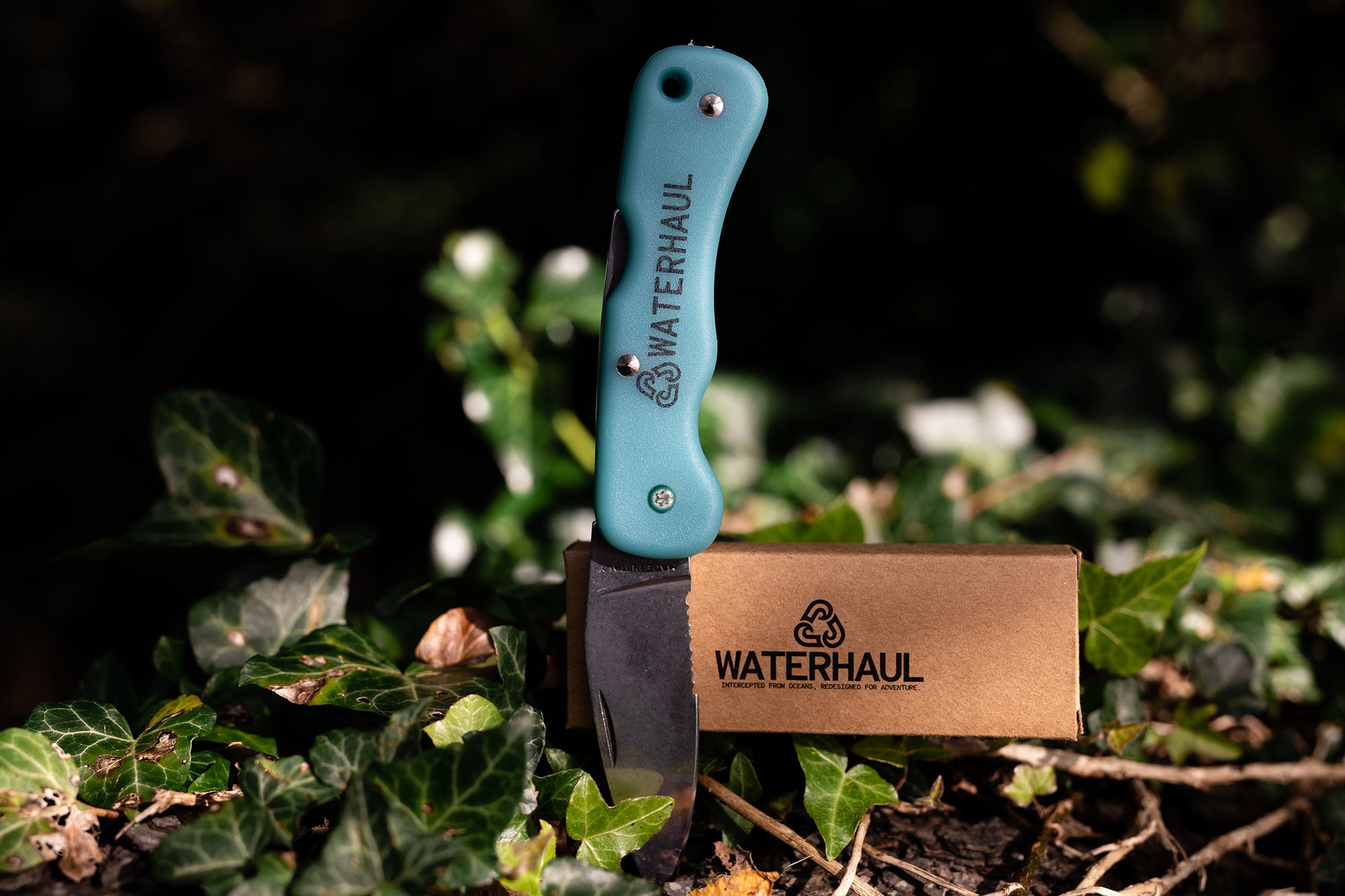 Waterhaul knife with brown cardboard box with leave sin background