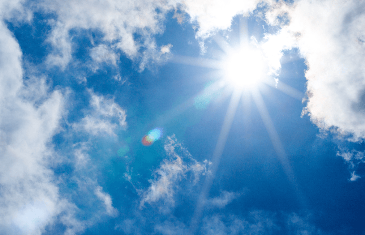 Blue sky with sun shining through clouds. 