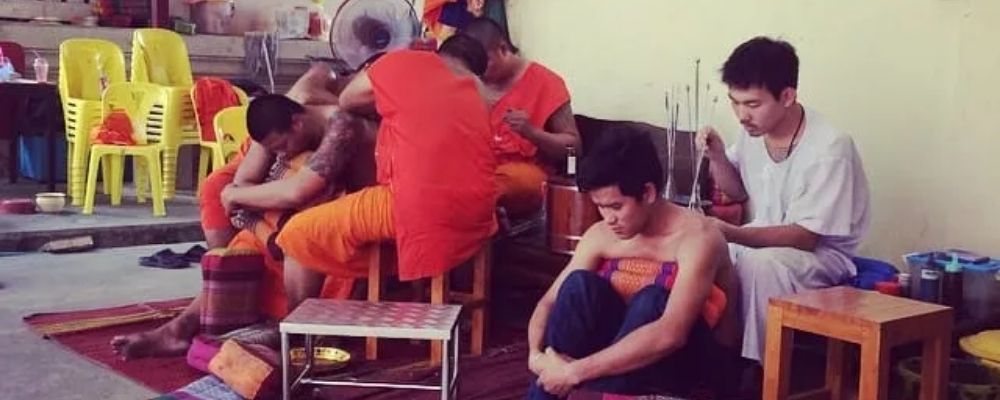 moines bouddhiste se faisant tatouer