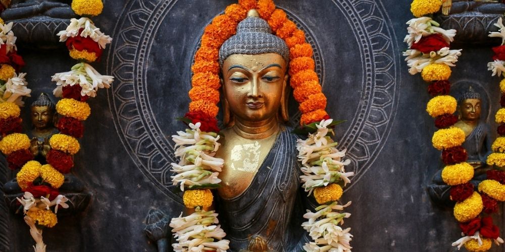 statue boudda couronne de fleurs