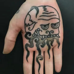 tatouage bouddhiste symbole tête de mort paume de la main