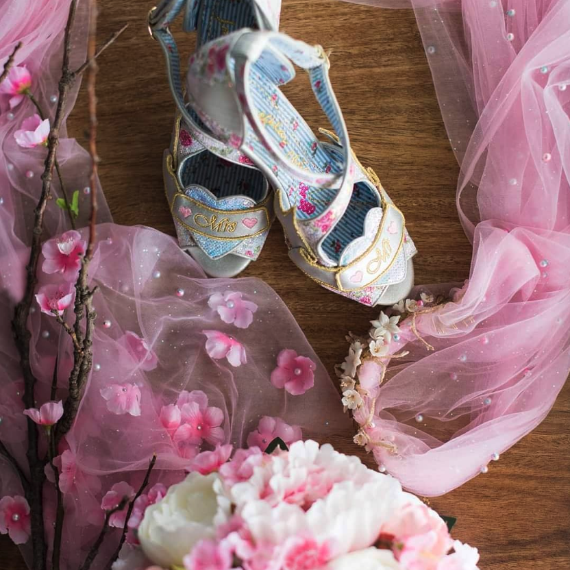 A closeup of Cher's shoes, surrounded by pink fabric and cherry blossoms