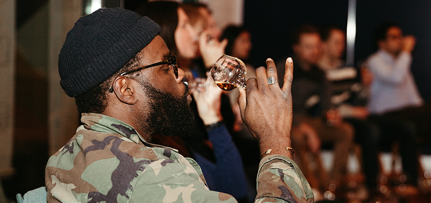 man swirling whiskey around in a glass