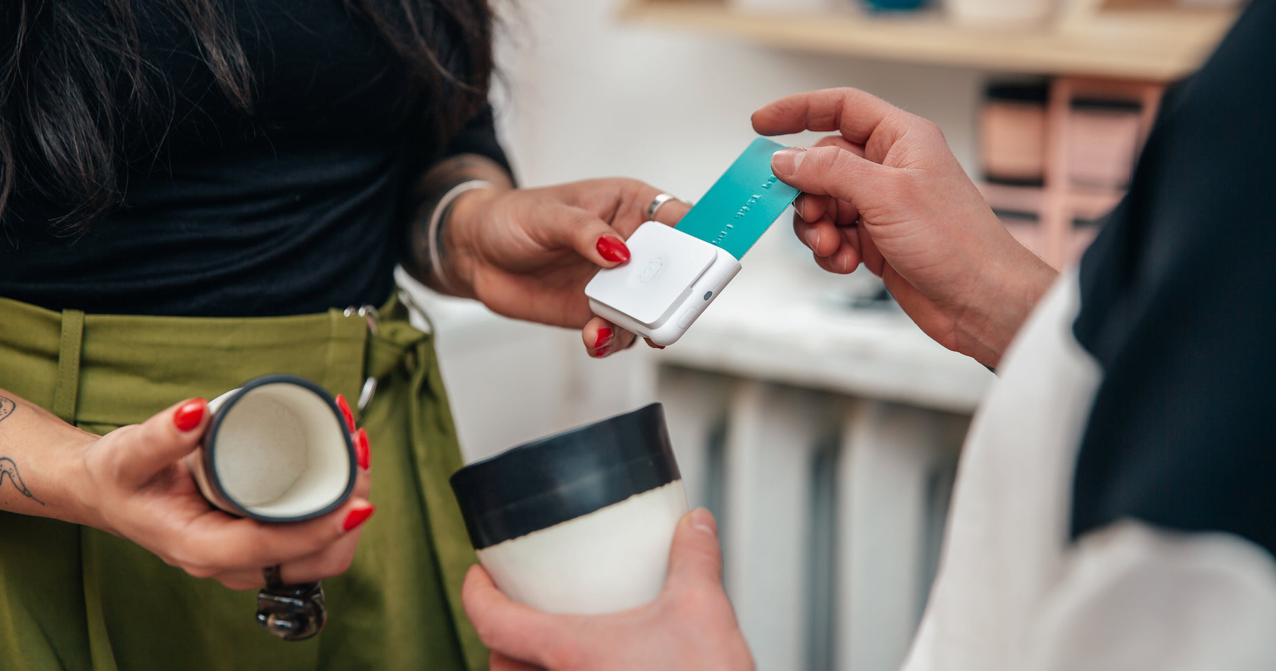 A small business owner using a chip and swipe card reader from Shopify to accept payment