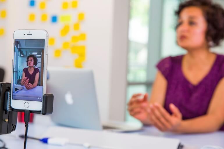 User interview: A woman is video recorded on an iPhone while speaking.