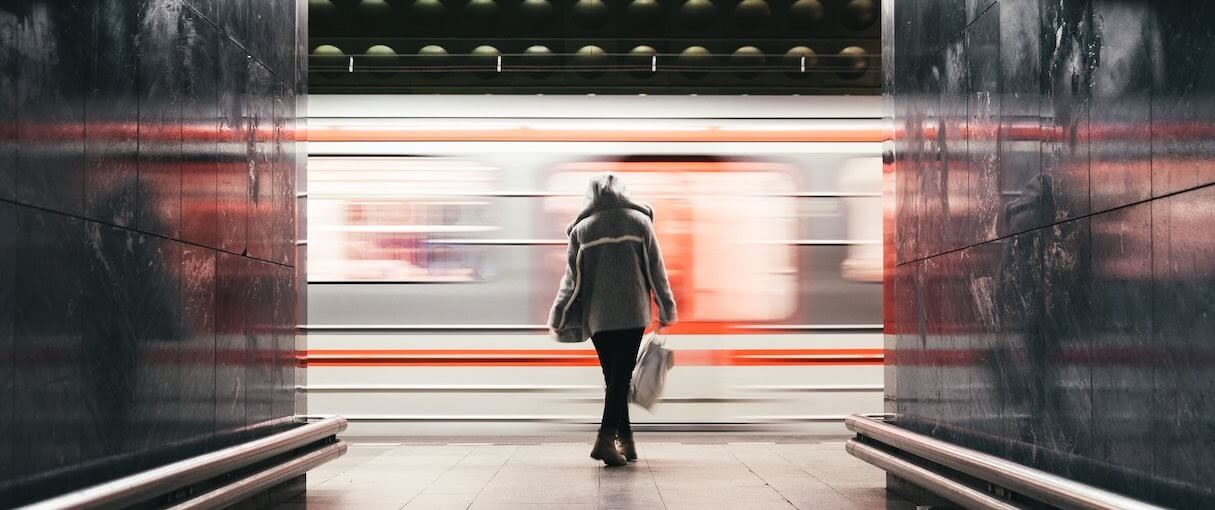 App performance: A woman waits on a subway platform as a train speeds by