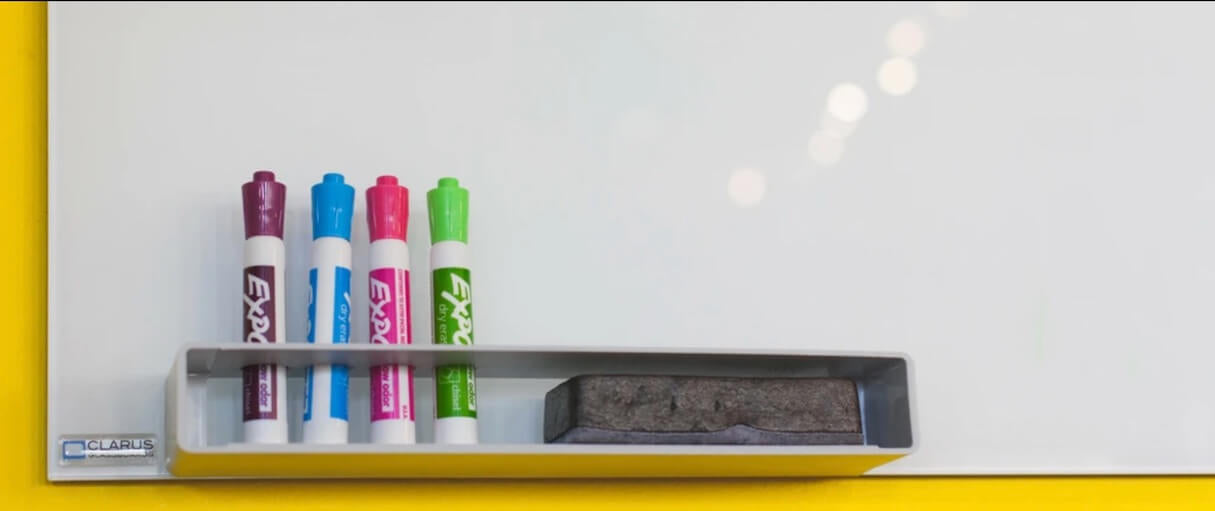 Image of whiteboard markers and an eraser in front of a whiteboard