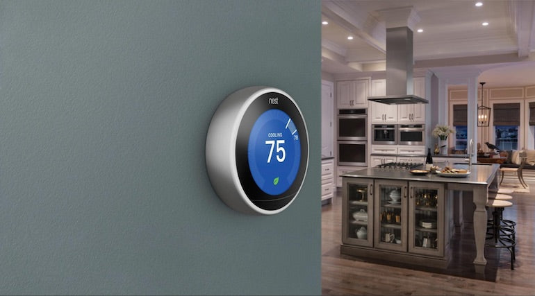 Microinteractions: Product photo of the Nest thermostat on a wall near a kitchen, showing 75 degrees Fahrenheit.