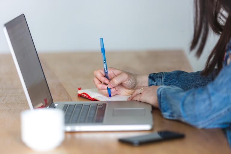 online workshop: person writing notes on a laptop