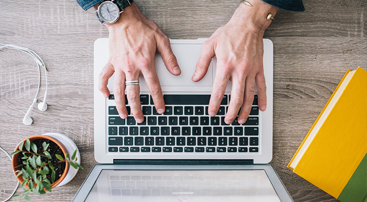 Rocket Code Scales From 10 to 25 Employees: Man typing on a computer, recruiting