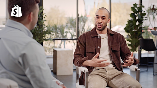 Jahmal Gittens sits for an interview wearing a brown shirt jacket and cream t-shirt.