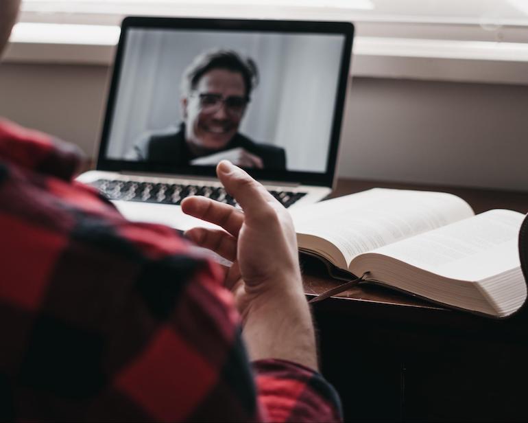 user research: person interviewing someone on a laptop