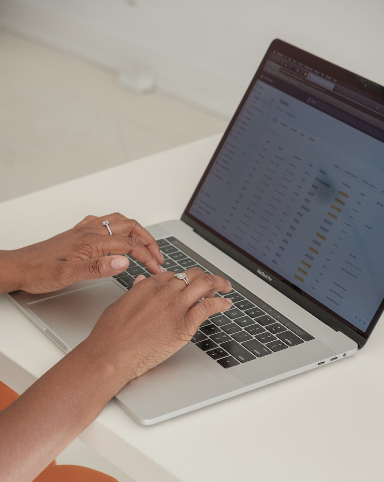 Image of a person working on a laptop (only hands visible)