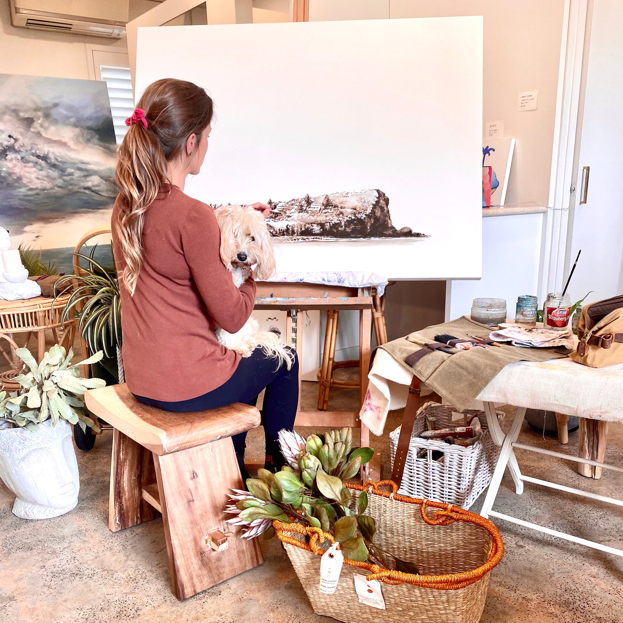 Nikki painting with her dog Luna on her lap