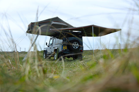 Land Rover defender with awning stretched out for a Northumberland adventure