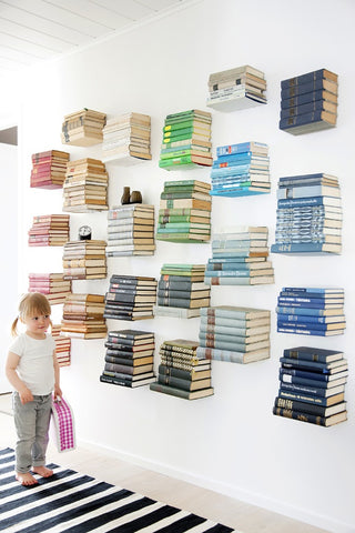 Books in rainbow colour order on floating invisible bookshelves