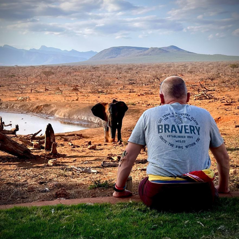 Ben Farrell overlooking a dry landscape with an elephant in the background