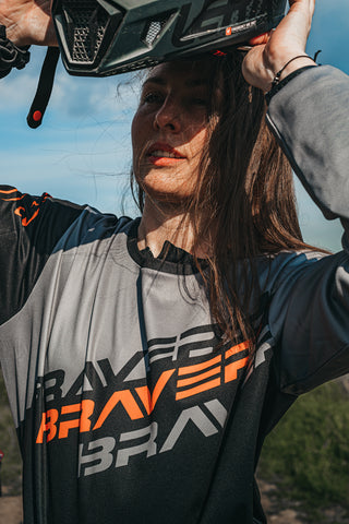 Picture of a lady putting on a motocross helmet about to ride