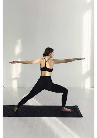 Woman executing warrior two yoga pose.