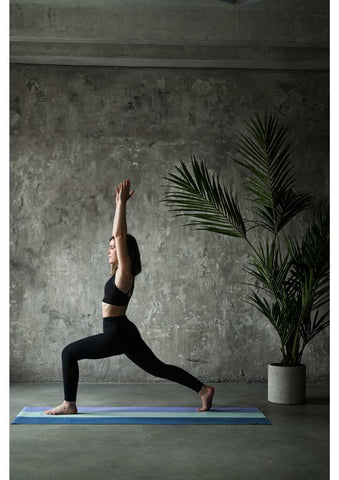 Woman executing warrior one yoga pose.