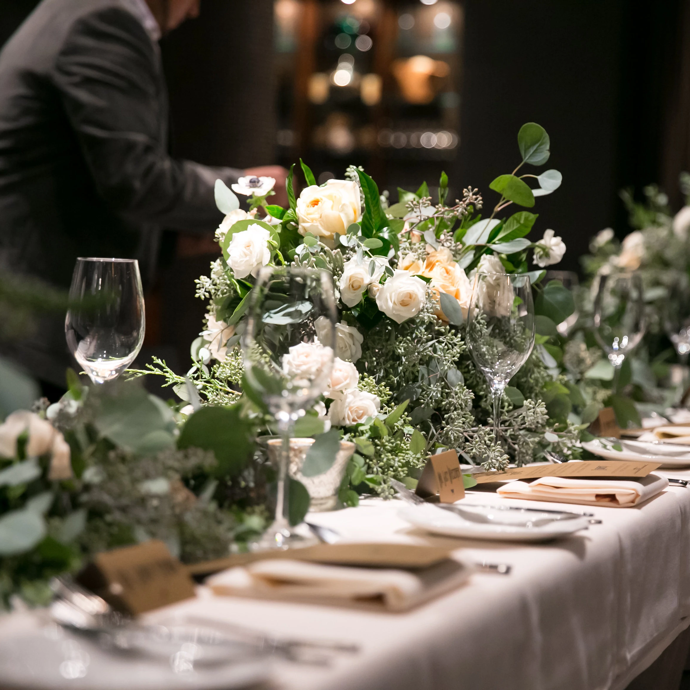 Wedding dinner tablescape with floral arrangements, wine glasses, and place settings