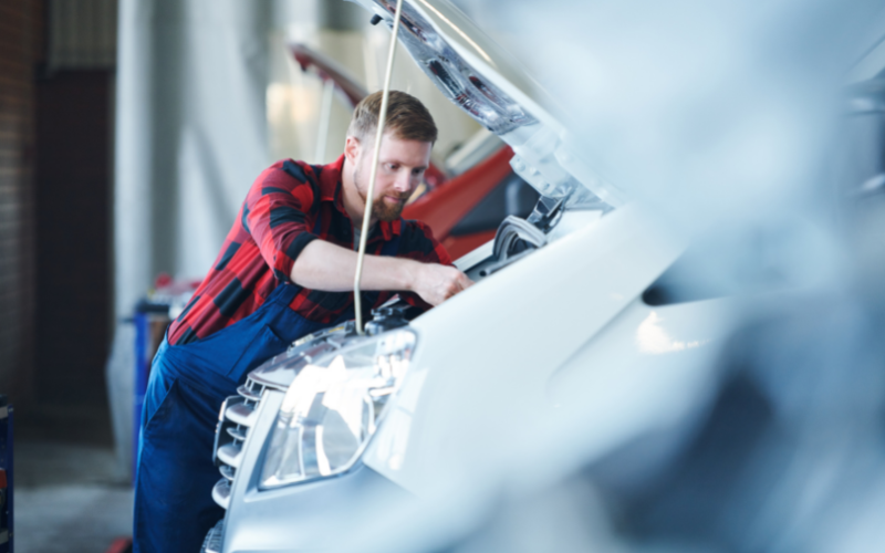 a white young man repairing a car to maintain its good working condition