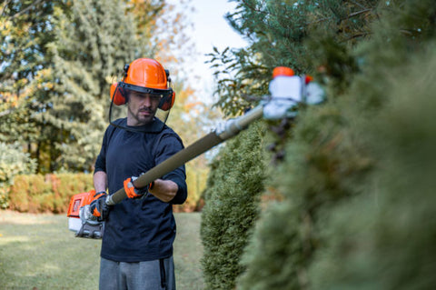 landscaper wearing PPE while trimming