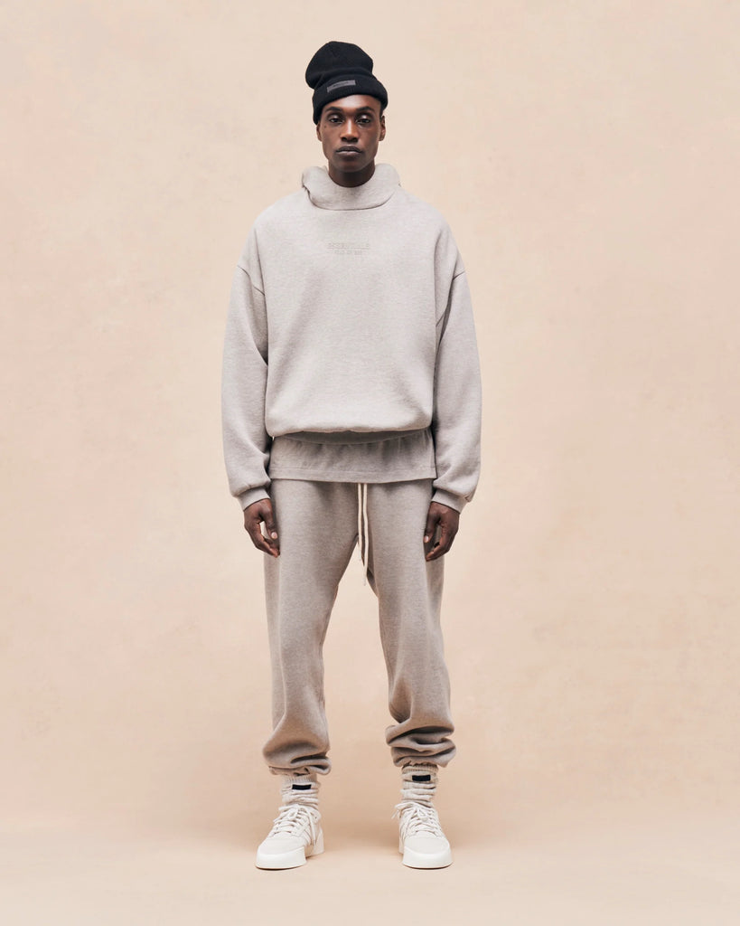 man standing wearing essentials hoodie