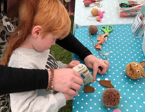 Little boy making a pom pom rabbit and Bovey Tracey Craft Festival.
